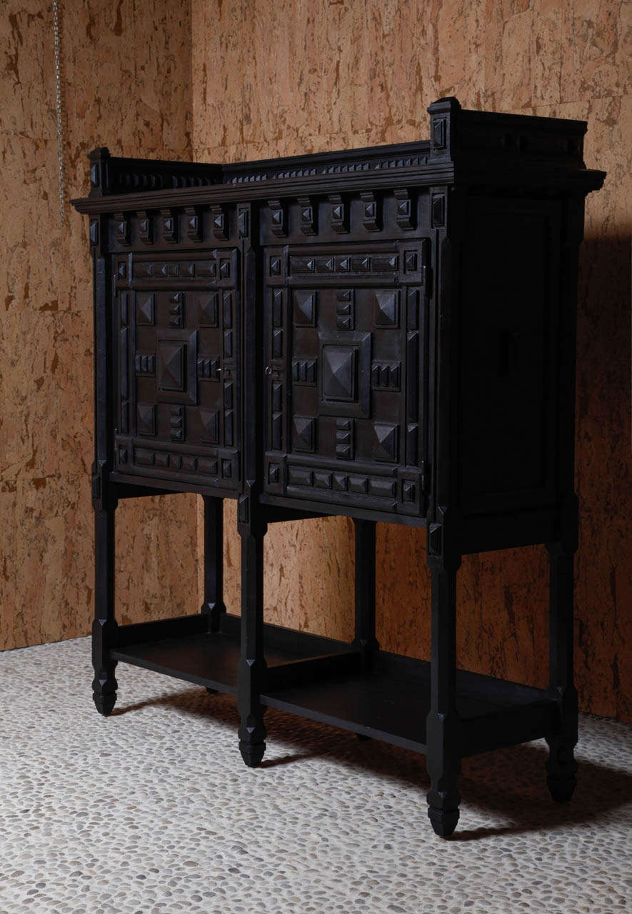 A 1910 antwerp oak ebonized cabinet on stand.