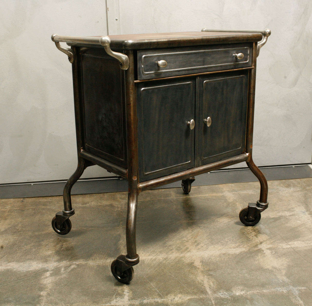 This little cabinet on curved legs with elegant handles is a beautiful piece with a refinished wooden top. The cabinet could be used as an end table, or storage for an office or parlor.