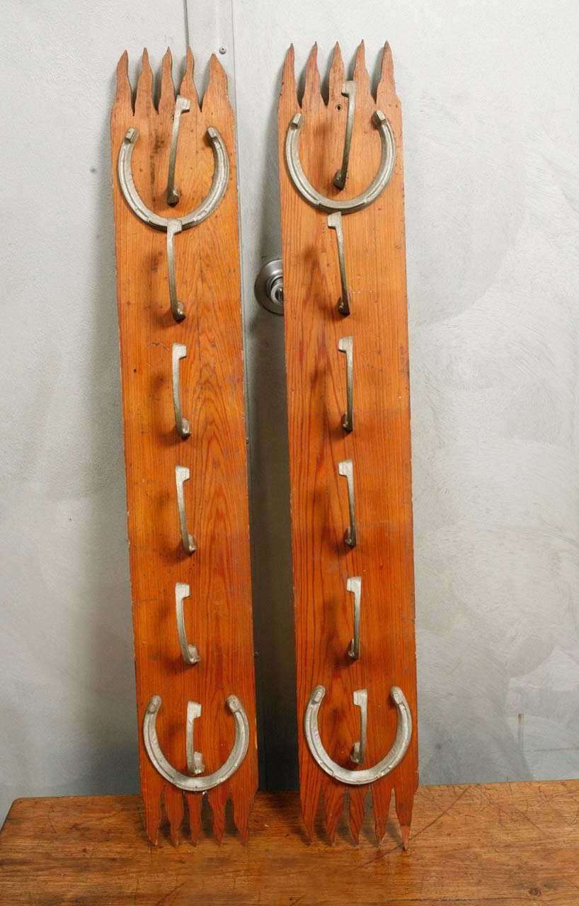 These are truly unique pieces of American antiques with hand carved wooden bases and metal horseshoes as hooks and a design elements. These racks were used for saddles and harnesses In lieu of saddles and harnesses hats and accessory would be just