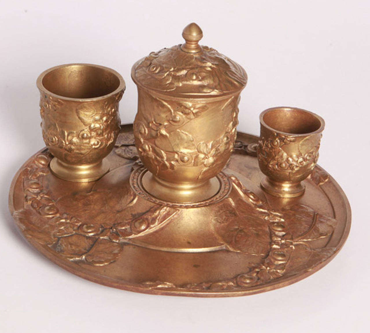 Handmade bronze inkwell consists of three removable cups, the largest of which has a removable top.  Inkwell depicts leaves and flowers.  Signed VieiAard.