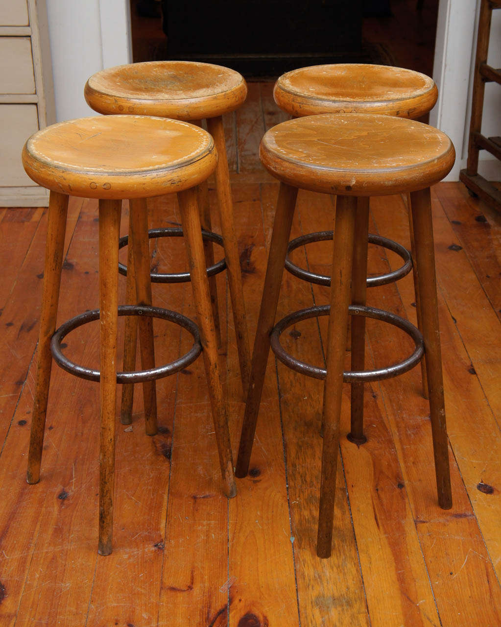 These stools came from a French bar in the south of France. Each is made of wood with a metal circular rim. This not only looks stunning, they hold the legs secure for a firm bar or counter stool. We buy these stools as tall as we can and they can