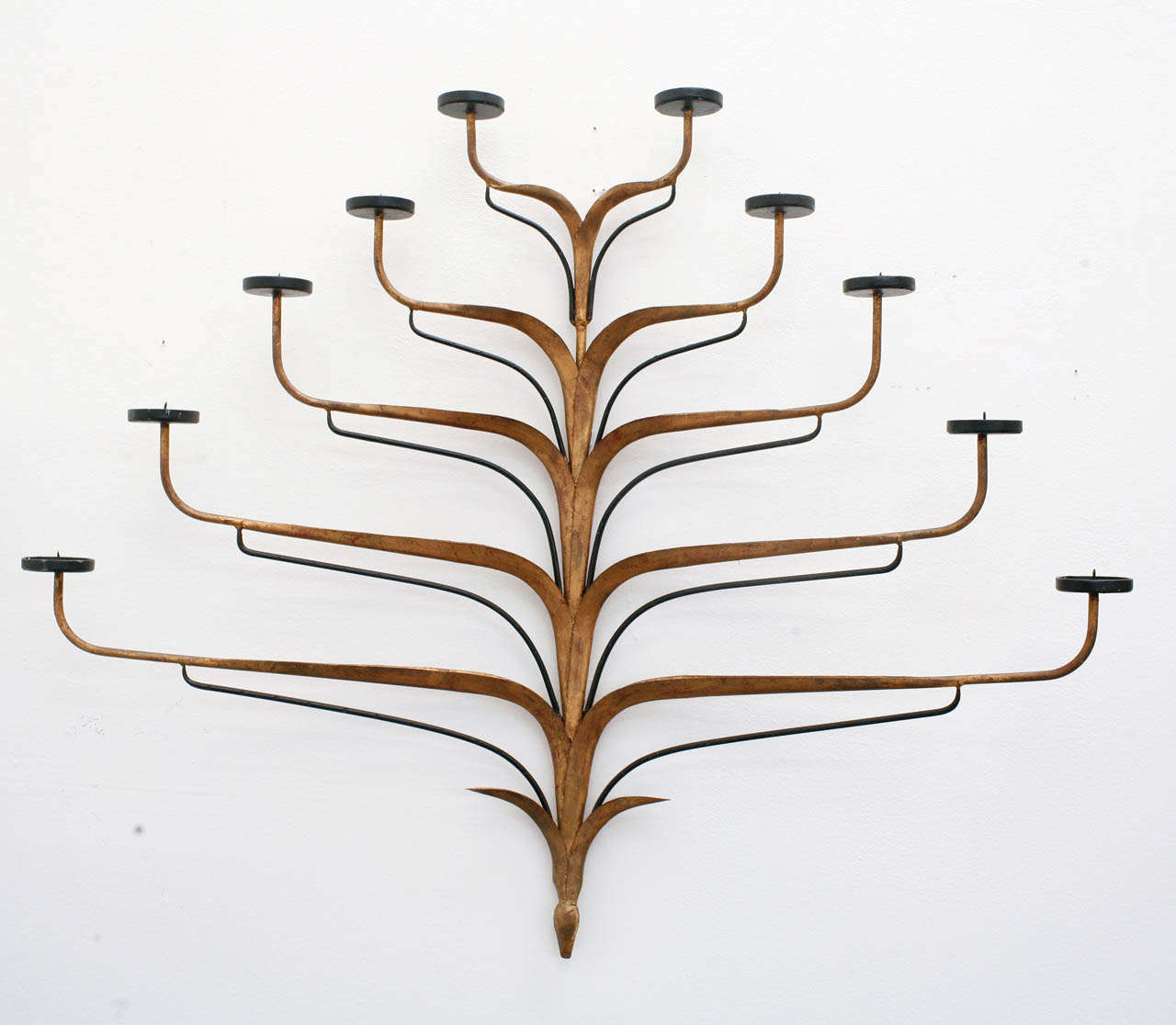 This incredible wall-mounted candelabra is truly more of a sculpture than anything else. Featuring ten undulating arms with recessed ends meant for tea lights, this metal Italian candelabra has a bronze patina and black details. Truly beautiful and