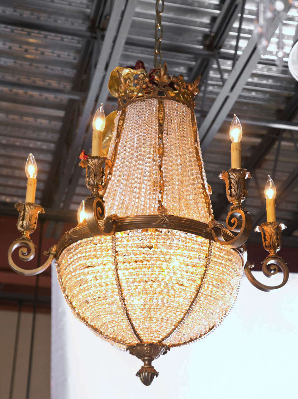 This antique French bronze chandelier is simply elegant. This ballroom chandelier is made with clear crystal balls in various sizes and mesh lining. The chandelier is 6 arm in torch style and has acanthus leaf, dogwood flower, and fleur de fleur