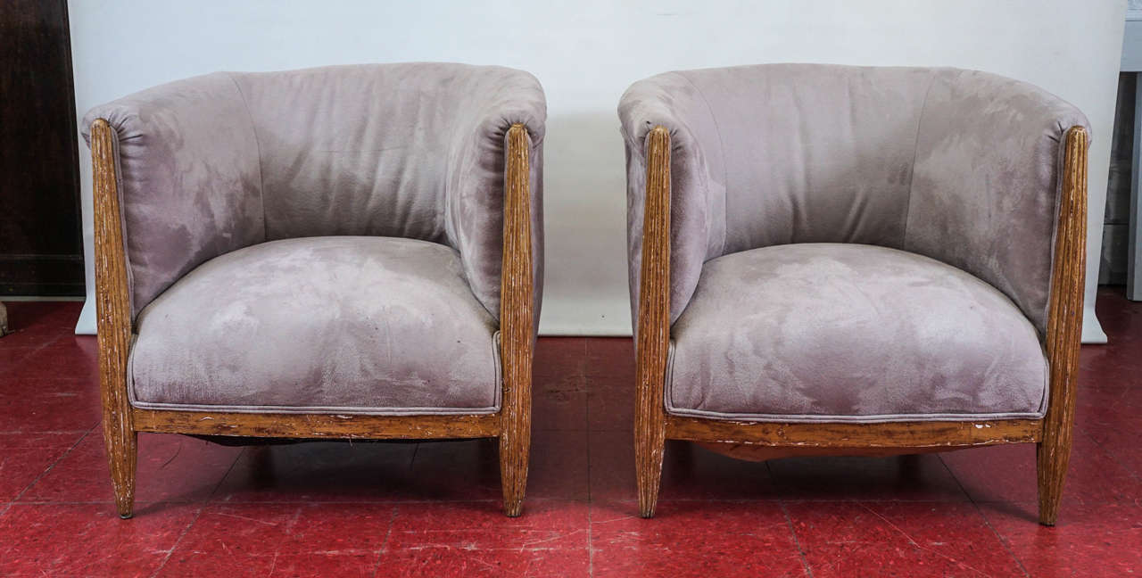 Unusual pair of French Art Deco armchairs with curved barrel backs and shaped fluted legs with rubbed gilt.  The fabric is taupe/grey ultra suede.

Seat Depth: 19