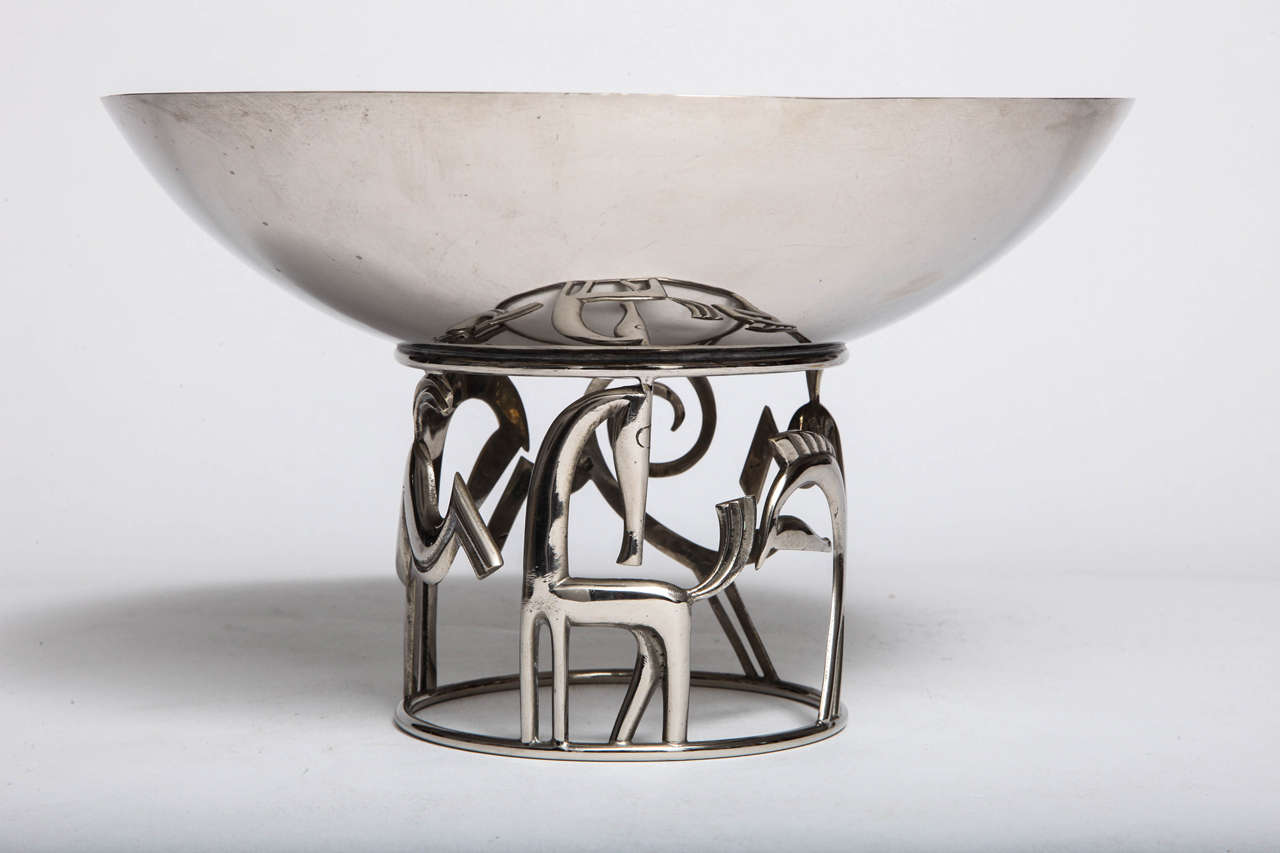 A nickel-plated brass Art Deco centerpiece designed by Karl Hagenauer for Hagenauer Werkstatte, circa 1930. The footed centerpiece has three stylized.
Horses and a dog. Marked Hagenauer Wien, WHW, Made in Austria.