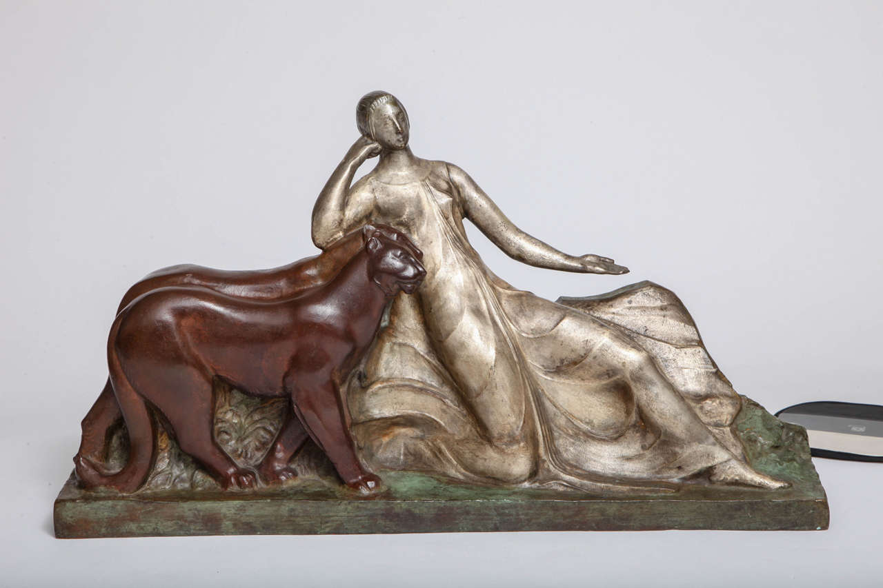 An Art Deco bronze sculpture of a reclining woman with two panthers, France, 
1925. The sculpture is triple patinated in silver, chocolate brown and green.
Signed Raoul Lamourdedieu and stamped bronze. Mint original condition.