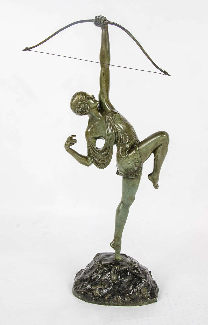 Diana, an Art Deco bronze figure by Pierre Le Faguays (1870-1938). A large, green patinated figure of the goddess Diana in stylized pose with her arrow standing on an integral naturalistic base.

Signed le Faguays and inscribed for Susses Freres