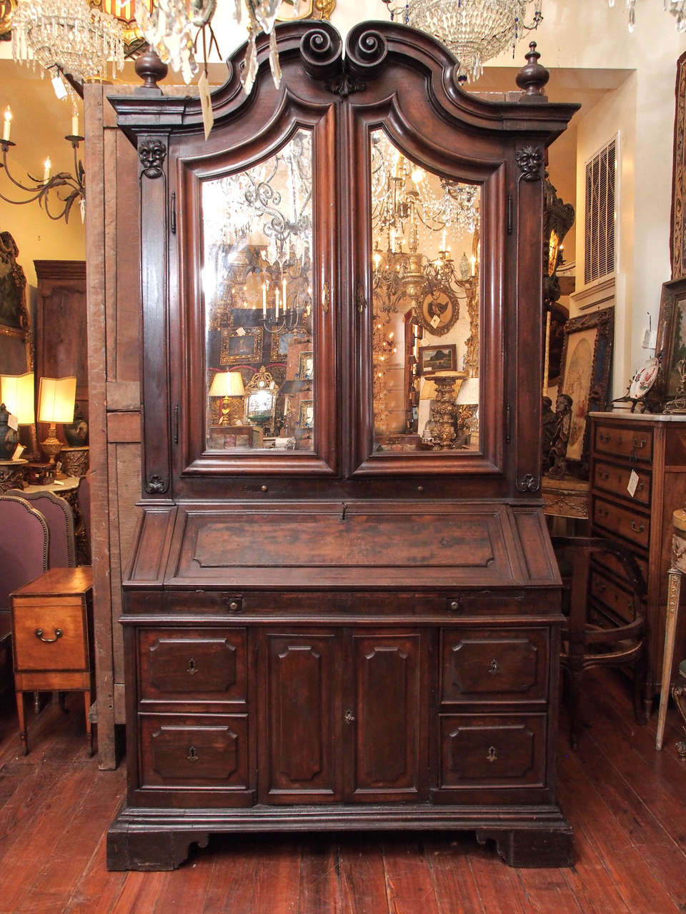 Late 17th century-early 18th century Italian walnut secretaire bookcase with mirrored doors and pediment top.