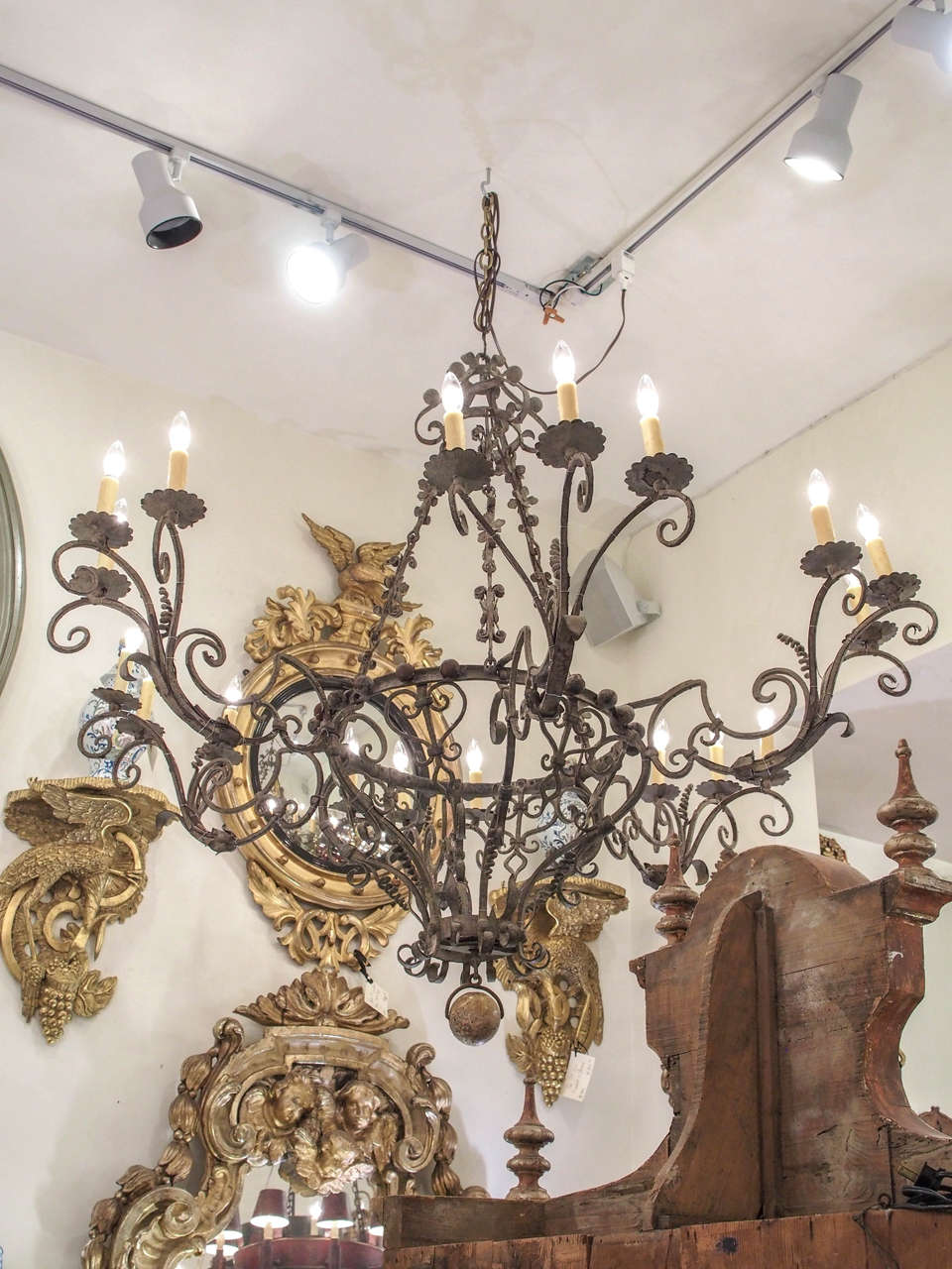 Exceptional Italian hand-wrought iron chandelier from the late18th century-early 19th century with 18 lights.
The entire frame is hand-wrought iron with a water gilt ball finial.