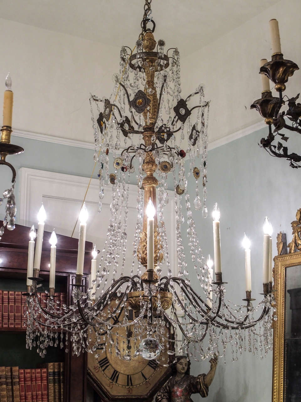 Pair of 19th century Genovese giltwood, iron and crystal twelve-light chandelier with crystal and brass medallions. This pair has the hand-wrought iron arms that fit exactly into the one spot on the central iron wheel as each is hand-cut. They have