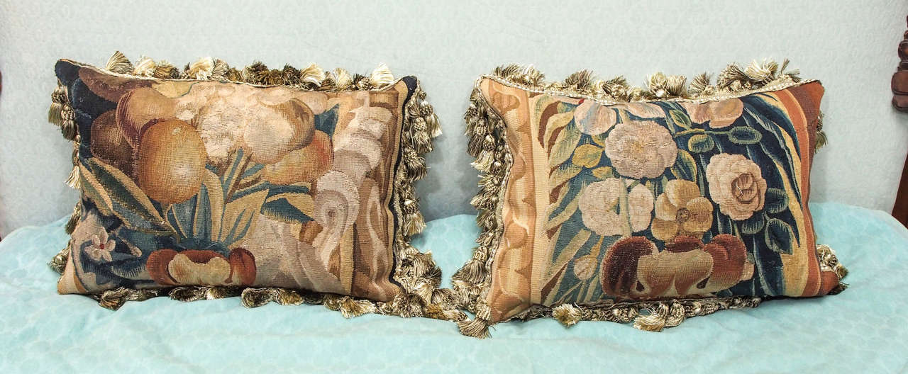 Pair of 17th century Aubusson tapestry fragments with bouquets of flowers and fruits now cushions with silk velvet backing, trim and down inserts.