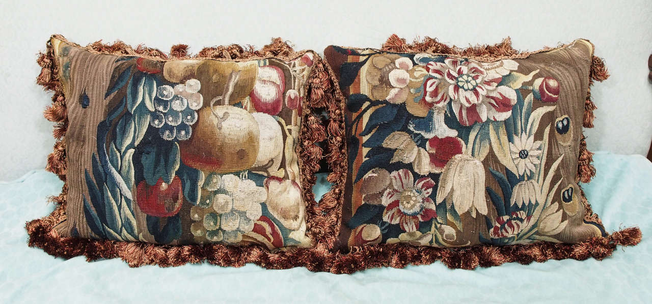 Pair of 17th century tapestry fragments now as cushions with silk velvet backing and silk tassel trim. Down inserts.