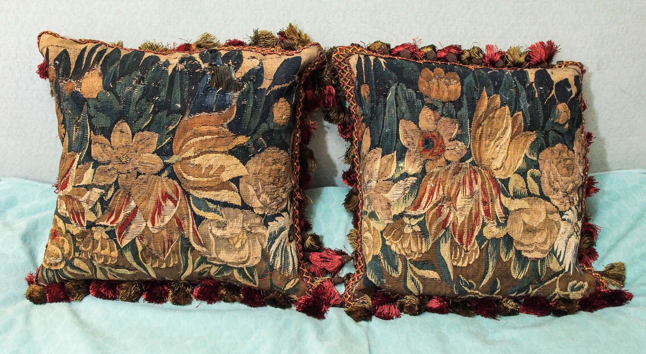 Pair of 17th century tapestry fragments depicting tulips now as cushions with silk velvet backing, trim and down inserts.