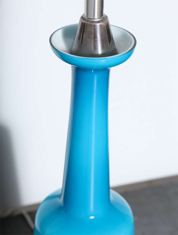 Skandinavische Moderne Otto Brauer für Holmegaard Cerulean Blue Glas Tischlampe.  Die schlanke Flaschenform in den Farben Aqua, Blau und Türkis ist mit einem weißen Innenleben auf einem versilberten Messingfuß versehen. Transluzent. Hell. Zeitlos.