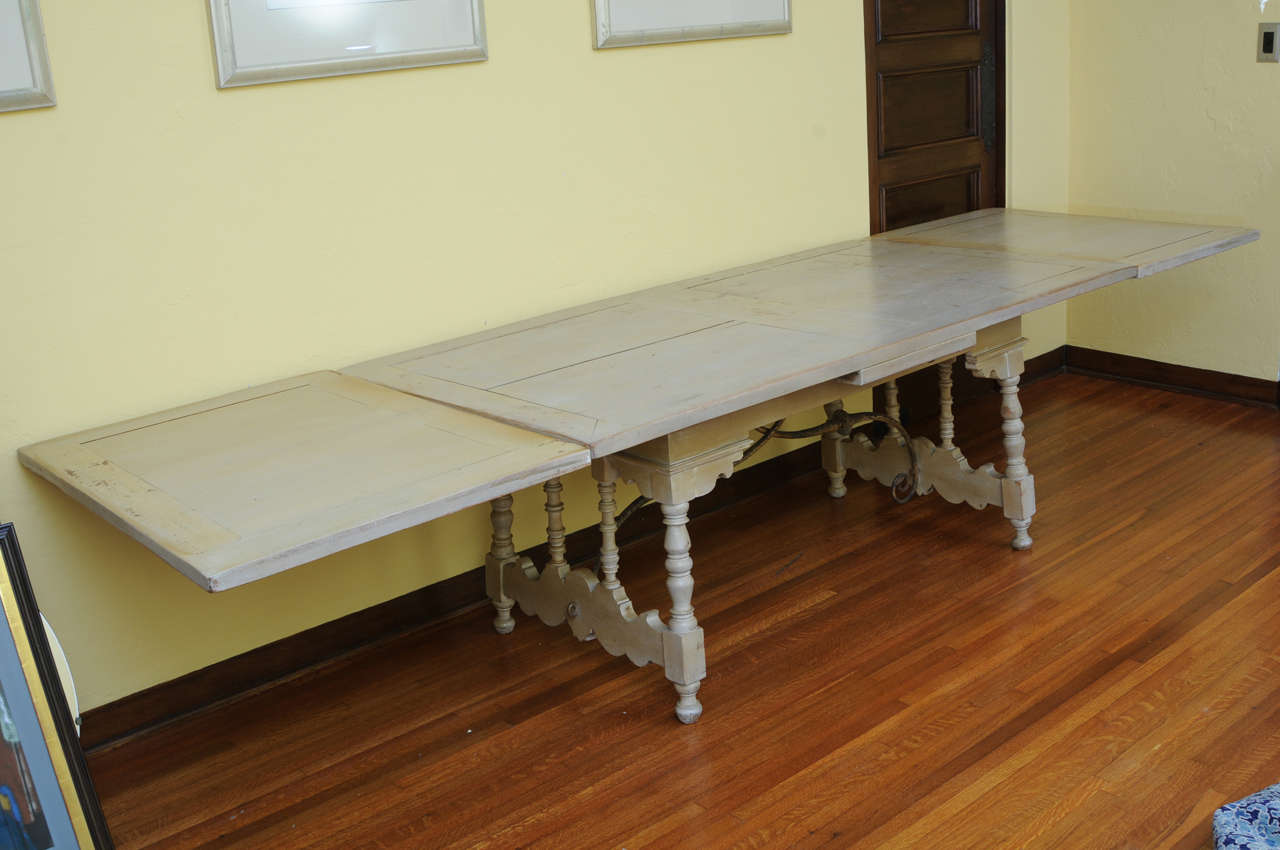 Spanish Revival trestle dining table attributed to Addison Mizner.  Length of table measures 72 inches and expands to 128 inches with two extensions.  Set includes 8 chairs (2 arm chairs and 6 side chairs), photographed separately. Price listed is