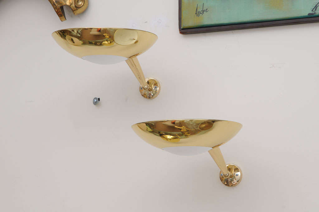 Pair of gilt bronze sconces in the style of Stilnovo with opaline glass and adjustable arms.
Lead-Time: 3-4 weeks. 