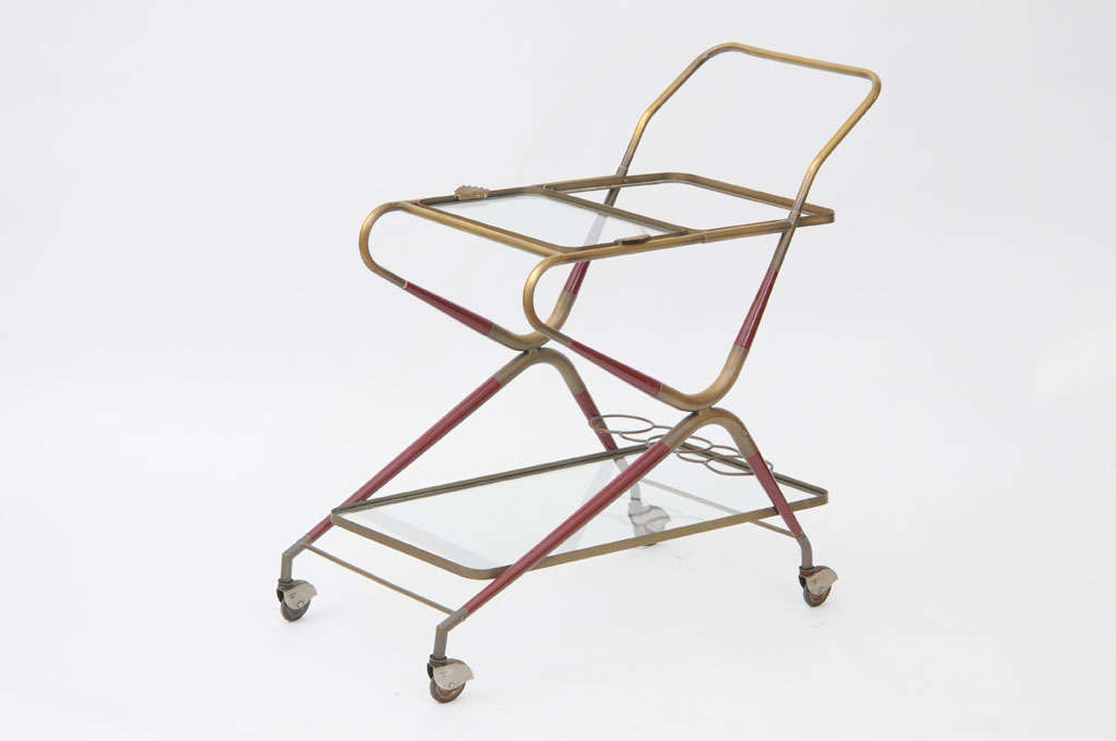 Mid Century Modern Bar cart with two levels with glass shelves and brass frame by Cesare Lacca.
Brass frame includes reddish stained wood inserts.
In good vintage condition one glass tray was replaced.