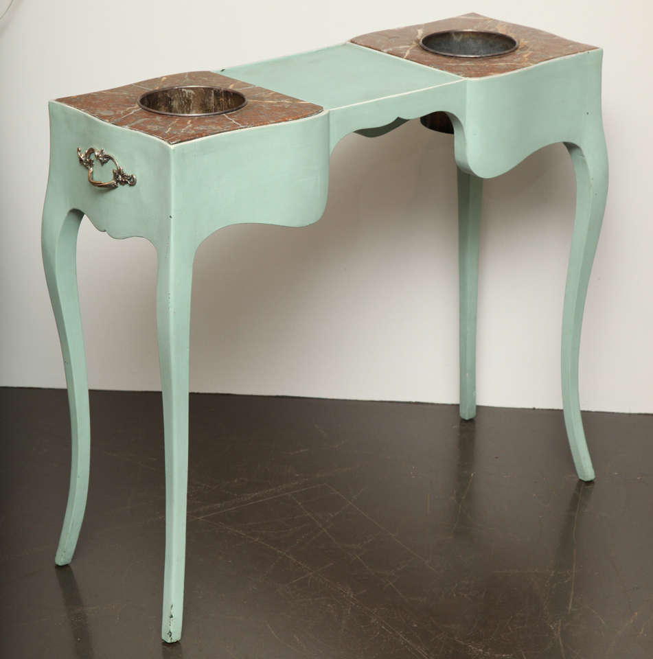 Double rafraichissoir in pale duck egg blue painted wood.
Inset marble top raised on cabriole legs and decorative metal handles on the side.
American, circa 1940.