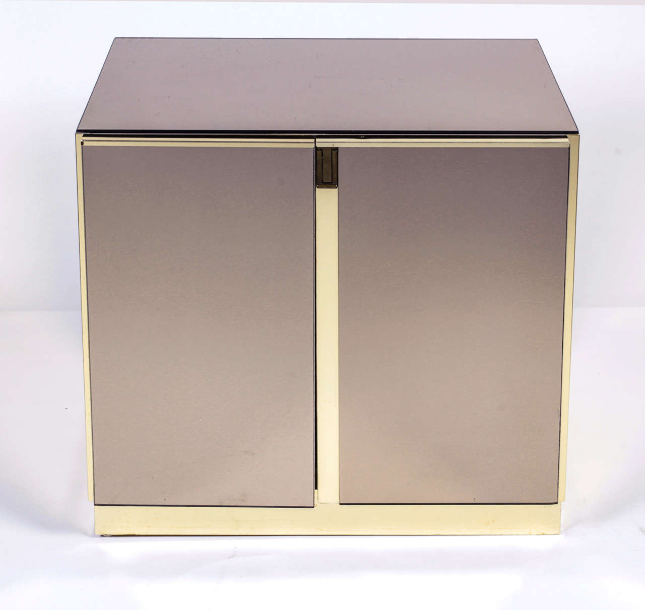 Pair of smoke mirrored nightstands with brass accents, in the style of Pierre Cardin.  USA. circa 1970.

Each cabinet features two doors with an adjustable inside shelf.  Top and drawer fronts are smoked mirrored brass; sides and case are polished
