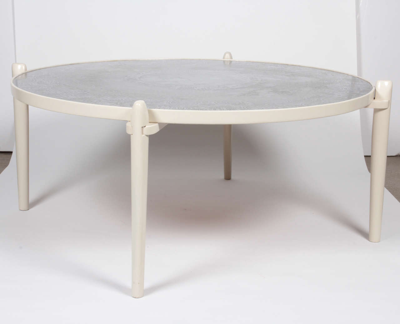 Circular coffee table etched aluminum, white feet in wood.
