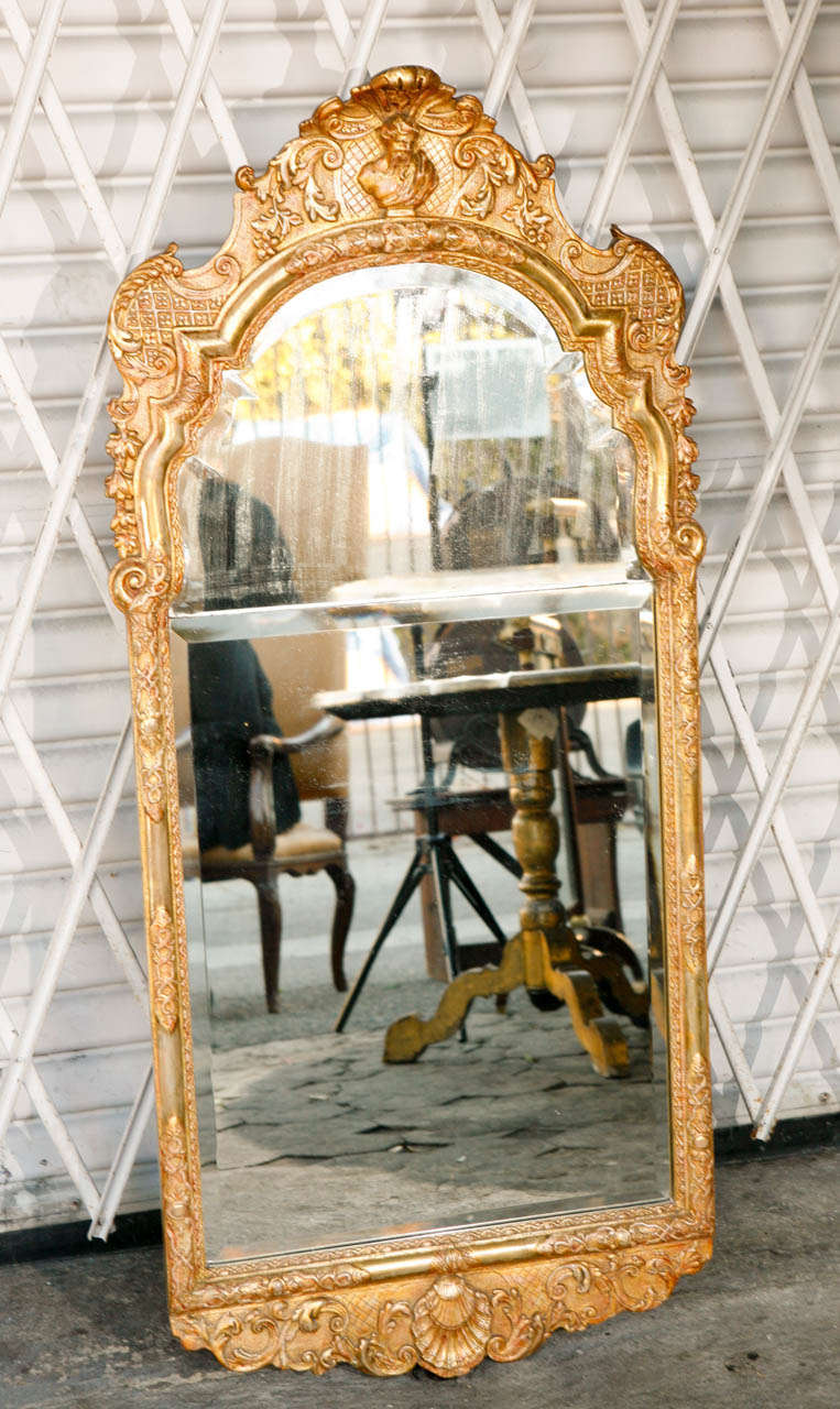 19th century English Giltwood and Gesso Mirror with original split plate beveled glass and shell motif on bottom.