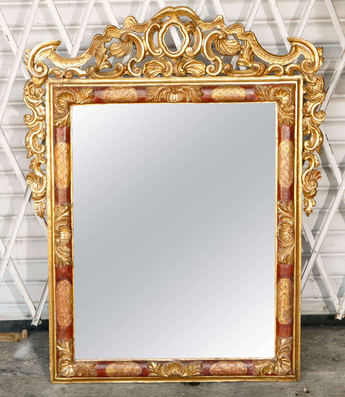 Miroir italien en bois doré sculpté de la fin du 18e siècle - début du 19e siècle, avec un bel accent rouge et doré.