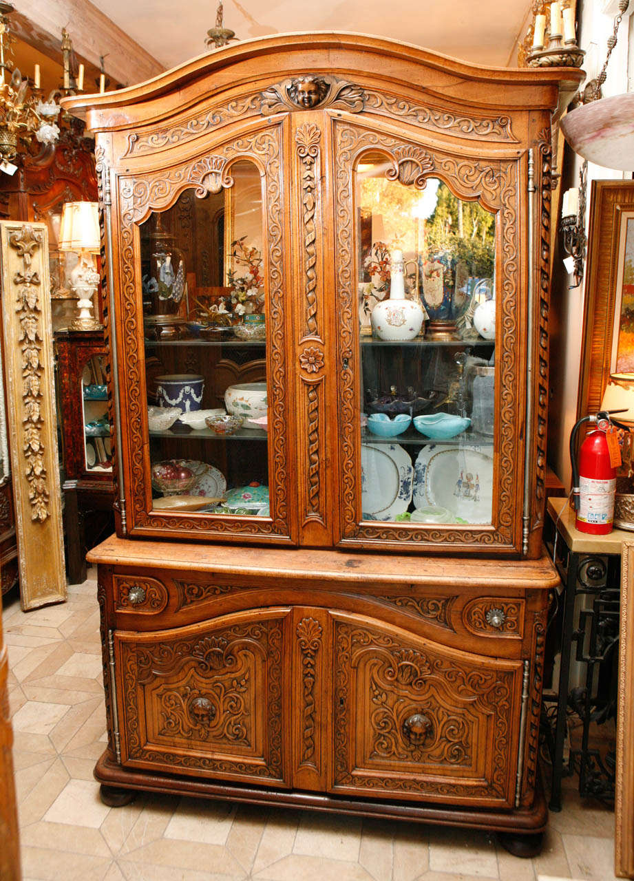 18th century French walnut two-part cabinet.  The cabinet is finely carved with two drawers and four doors.