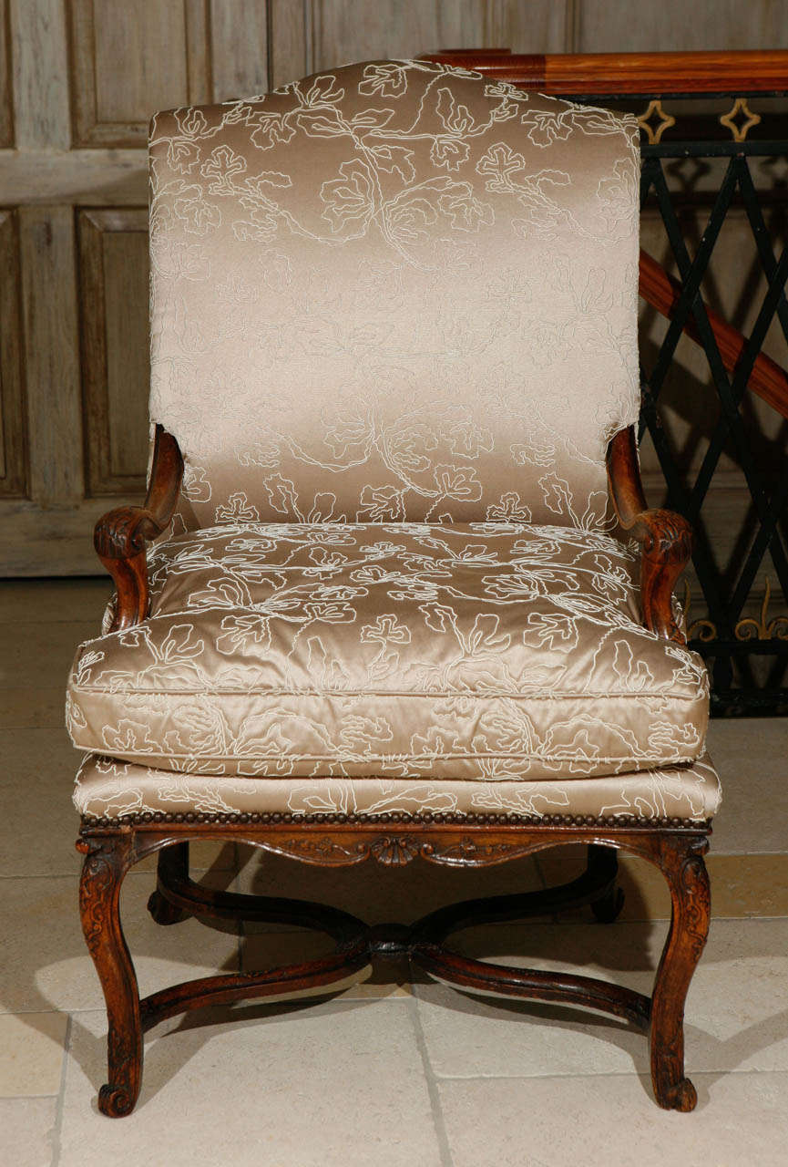 18th century French Regence single finely carved walnut armchair with stretcher. The chair has been newly upholstered in silk fabric.