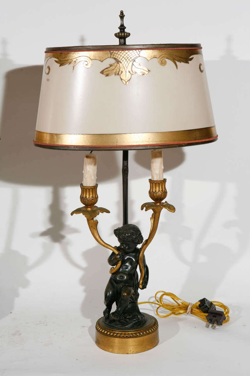 Pair of Late 19th c. French Bronze 2 Arm Candelabras Converted to Lamps with Child Figures.The Shades are included and are Hand Made of Parchment Paper. They are Hand Gilded and Decorated.  The lamps have been newly wired. The base measurement is