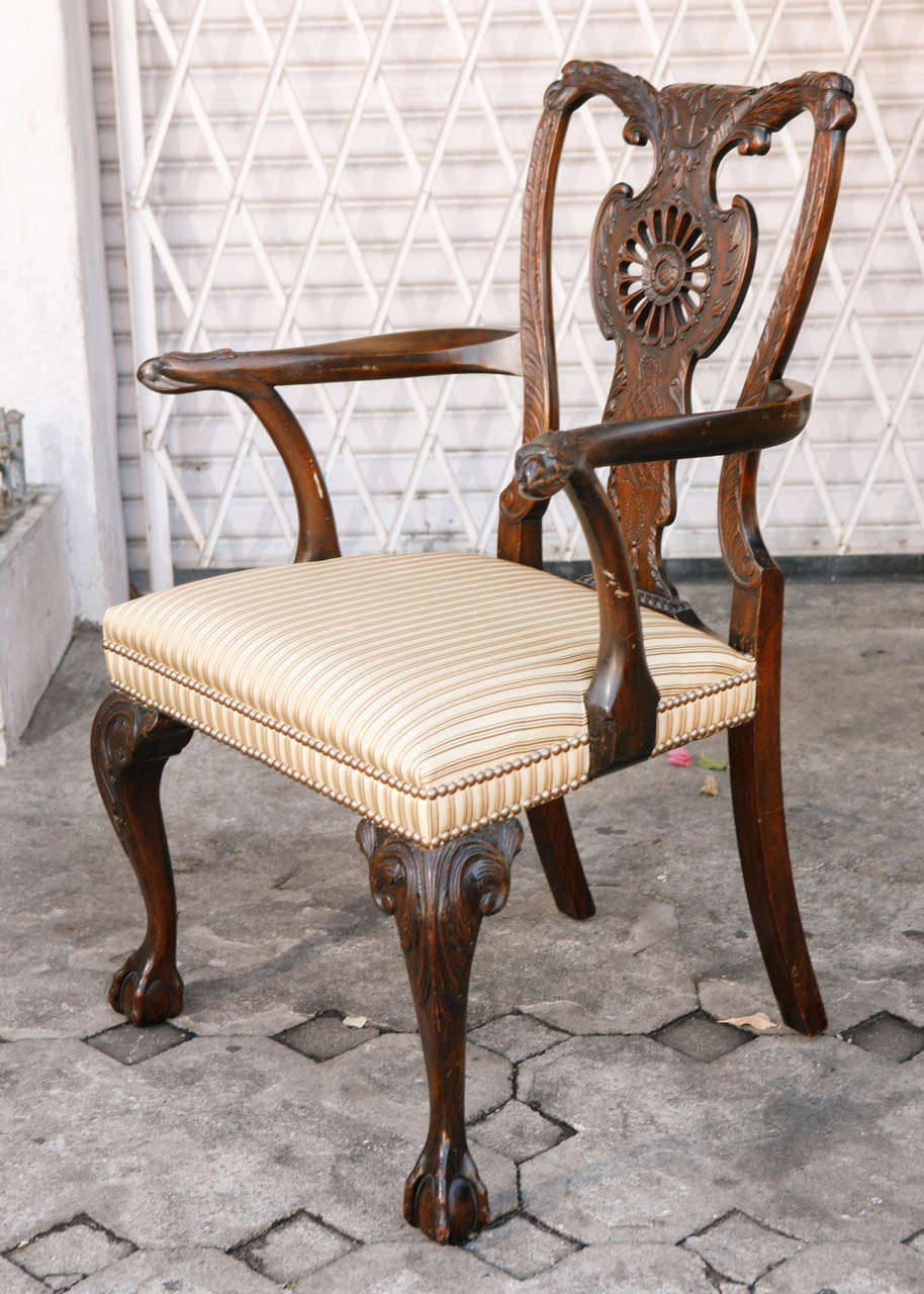 Pair of very fine 1900s English Carved Walnut Chairs with Eagle Head Motif.  The chairs have been upholstered in a striped silk fabric.