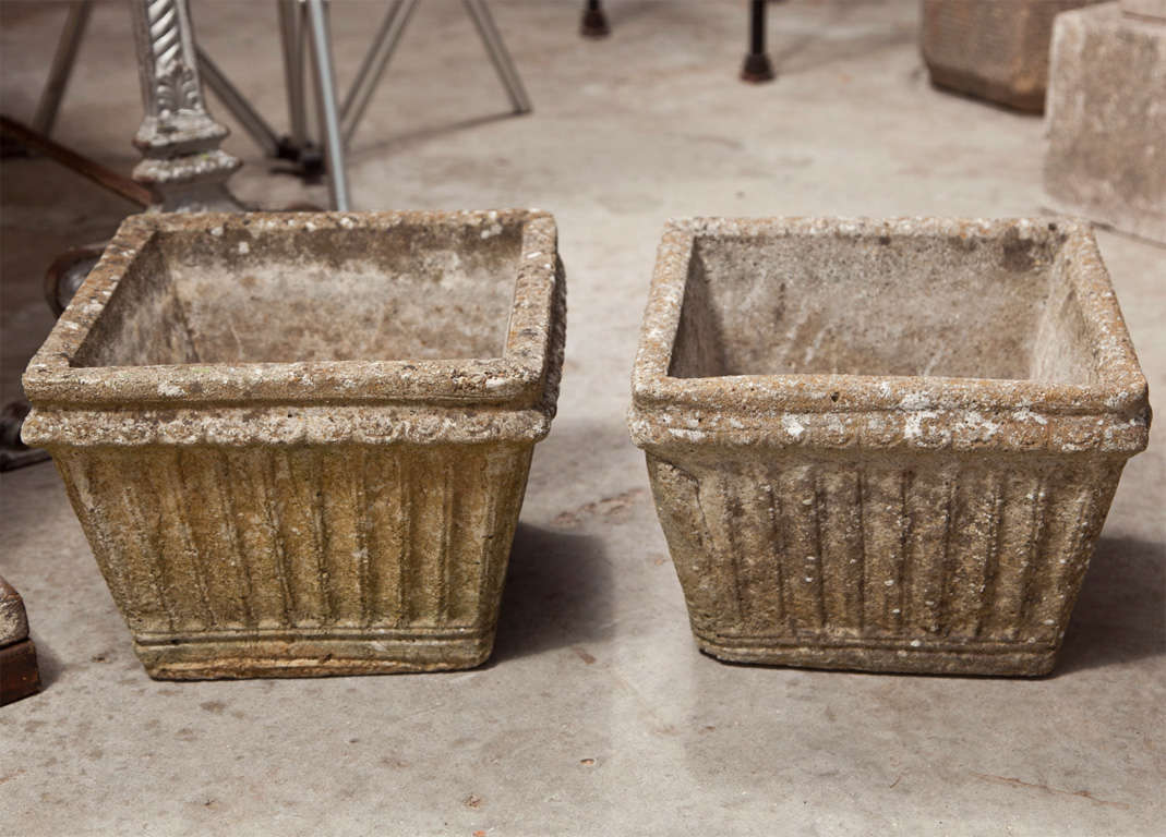 This charming set of four cast stone planters from England is heavily weathered with lots of lichen and will get mossy if kept in a moist and shady spot during the summer.  Very simple, but rustically-elegant in form, they feature a vertical fluted