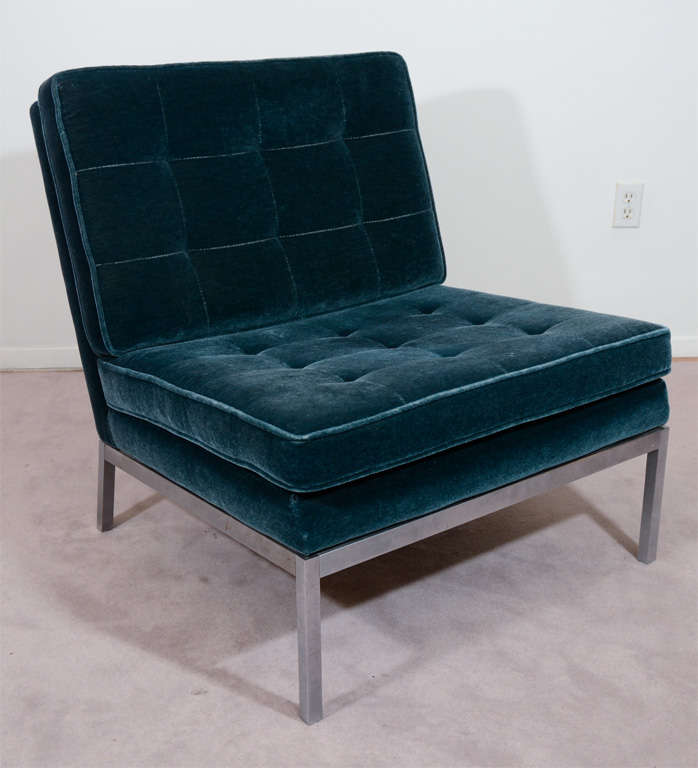A single vintage chair in teal-blue tufted velvet upholstery with stainless steel legs. The piece is by noted designer Florence Knoll.