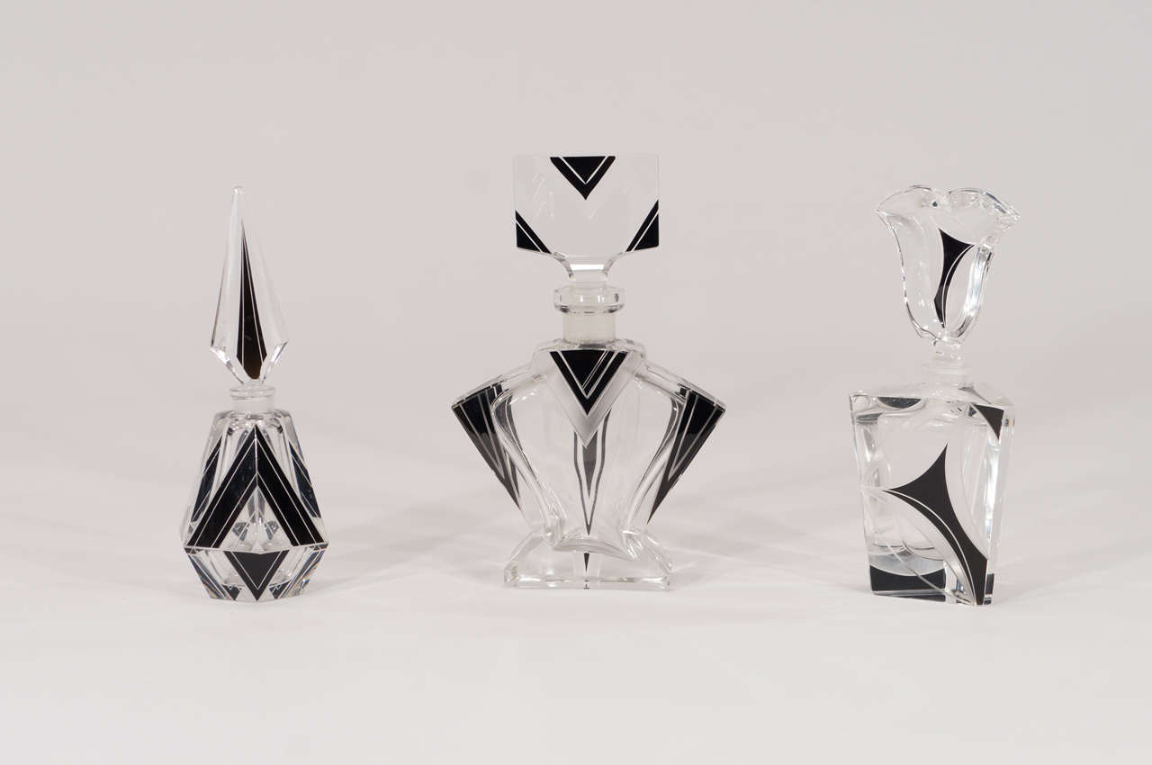 A collection of Art Deco hand blown and molded crystal perfume bottles with a variety of interesting shapes and sizes. Each one is unique and presents a different Deco style with black enamel and engraved decoration. Designed and made by the Czech