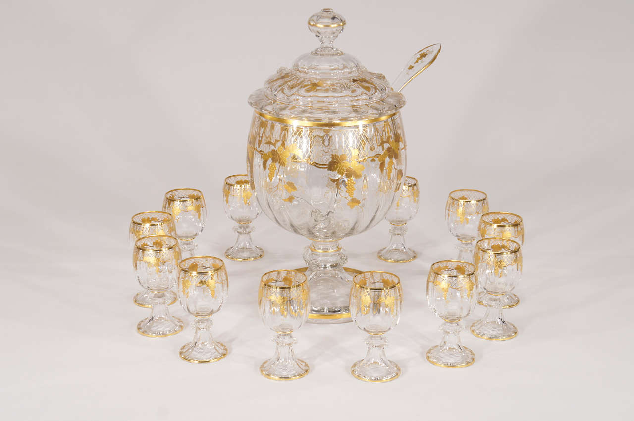 This is a rare Lobmeyr complete punch set comprised of a hand-blown lidded and footed punchbowl with 12 matching punch cups. This exquisite example has optic rib internal decoration and applied prunts and is further embellished with a hand-painted