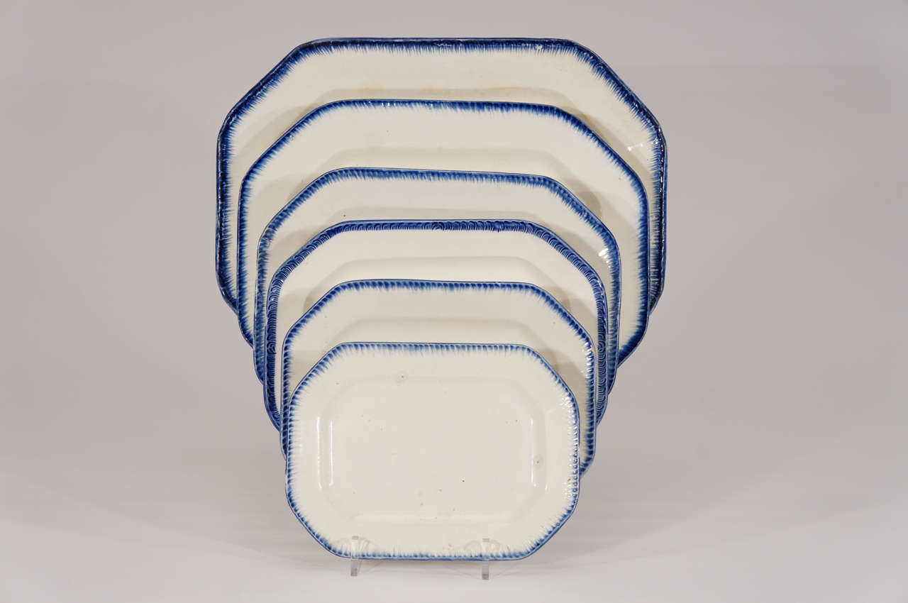 This rare and wonderful set of 6 late 18th c. creamware platters was made by Leeds pottery and features the classic blue shell edge borders. Perfectly matching, the graduated sizes are nestled one inside the other, making a wonderful display and