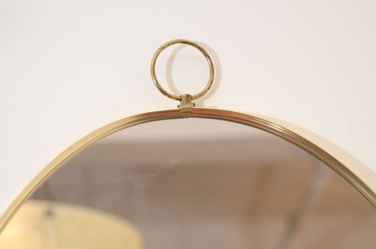 Hollywood Regency 1960s Graceful Oval Brass Mirror with Finial Detail