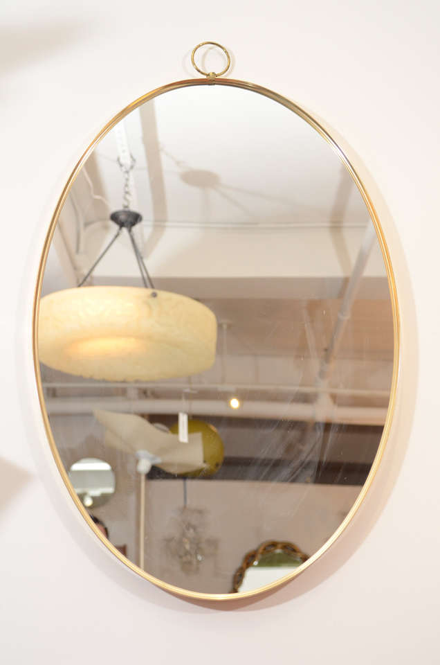 Mid-20th Century 1960s Graceful Oval Brass Mirror with Finial Detail