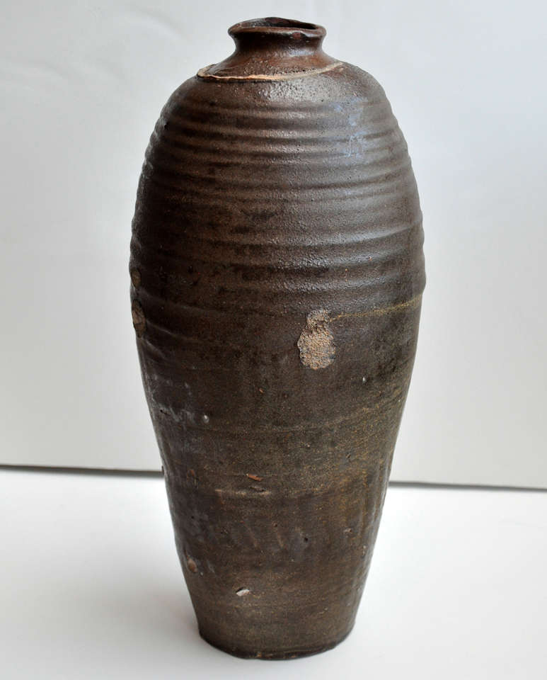 Extra large Jin Dynasty wine bottle with dark rust colored glazed.  The ring is from the storage cap.  The small areas without glaze are points where the jar touched other jars during firing. 
