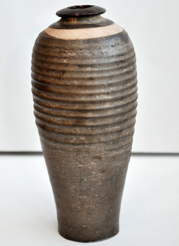 15th century or earlier Chinese wine bottle. Elegant glaze and ribbing details. Finish is varying shades of brown. From the Jin dynasty.