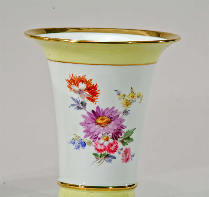 This lovely pair of signed Meissen vases are beautifully painted on both front and back with Dutch floral bouquets. The crisp white background with vibrant yellow, provides contrast to the bold polychrome enamels of the floral painting. The gold