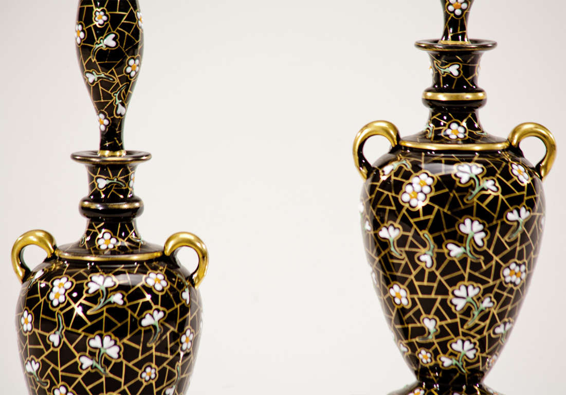 Wonderful pair of hand blown, black crystal perfume bottles with matching stoppers.The entire body is hand painted with raised enamel flowers and highlighted in gold. The stoppers are shaped like small vases as they were probably also used as