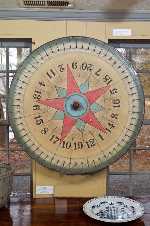 A considerably sized early 20th century Wheel of Chance. A very fine example in it's original hand-painted surface with a bold red and blue central double star, black numbers and a scalloped green border. What makes this one rare is how the