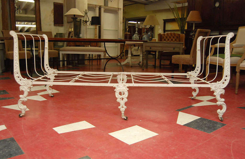 White painted iron campaign bed, Canadian 19th C., by Ives & Allen of Montreal.  Rococo-inspired with C-scroll decoration, raised on casters; bed frame is cleverly designed to fold for storage.