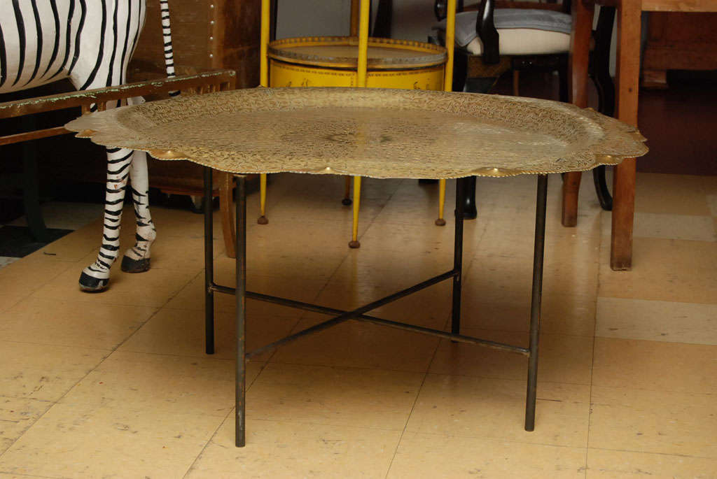Intricately etched large brass tray coffee table with iron metal folding base.