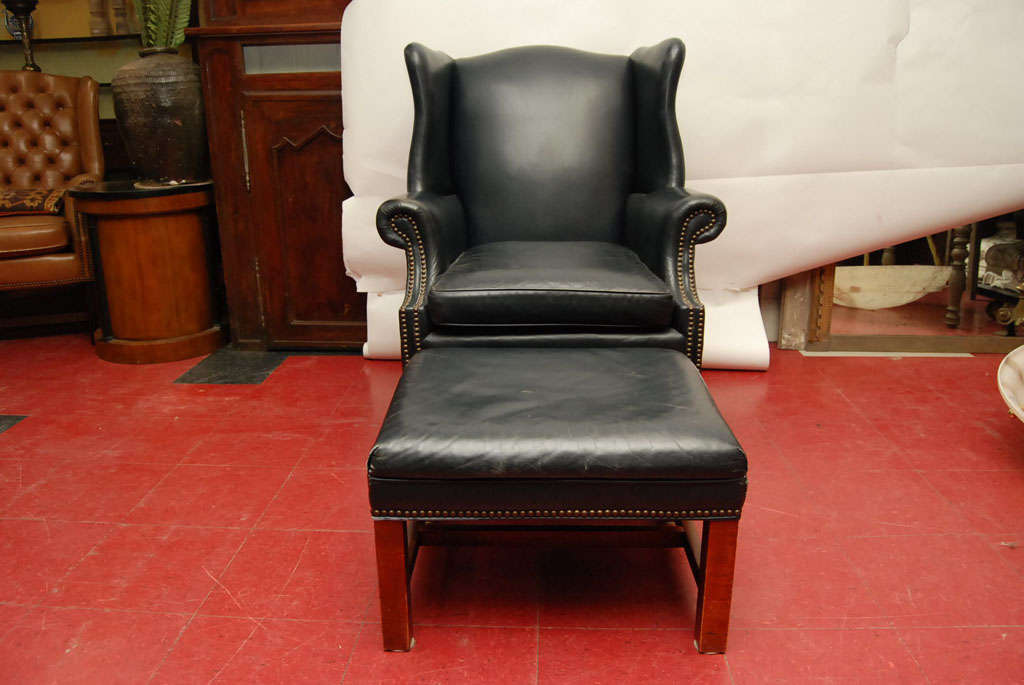 Leather wingback chair and ottoman with nail heads.