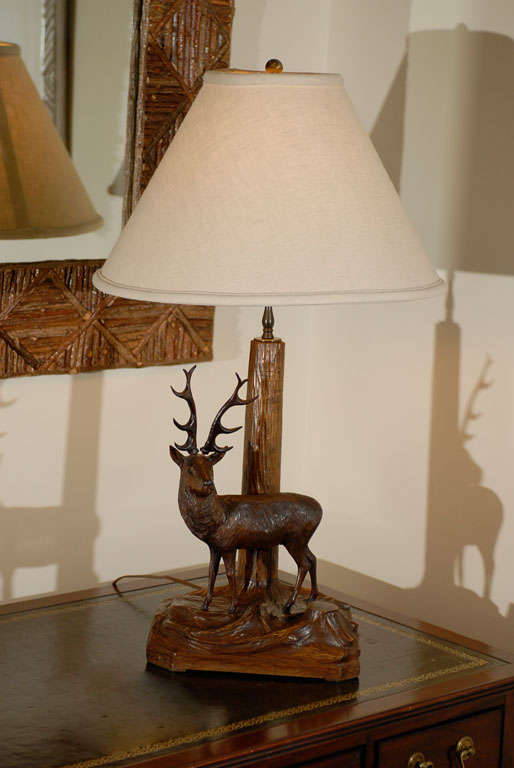 This is a wonderful stag or deer lamp.  The stag is standing in front of the tree which is the neck of the lamp.  The carving is beautiful.<br />
Black Forest started in the village of Brienz outside the popular city of Berne, Switzerland. Black
