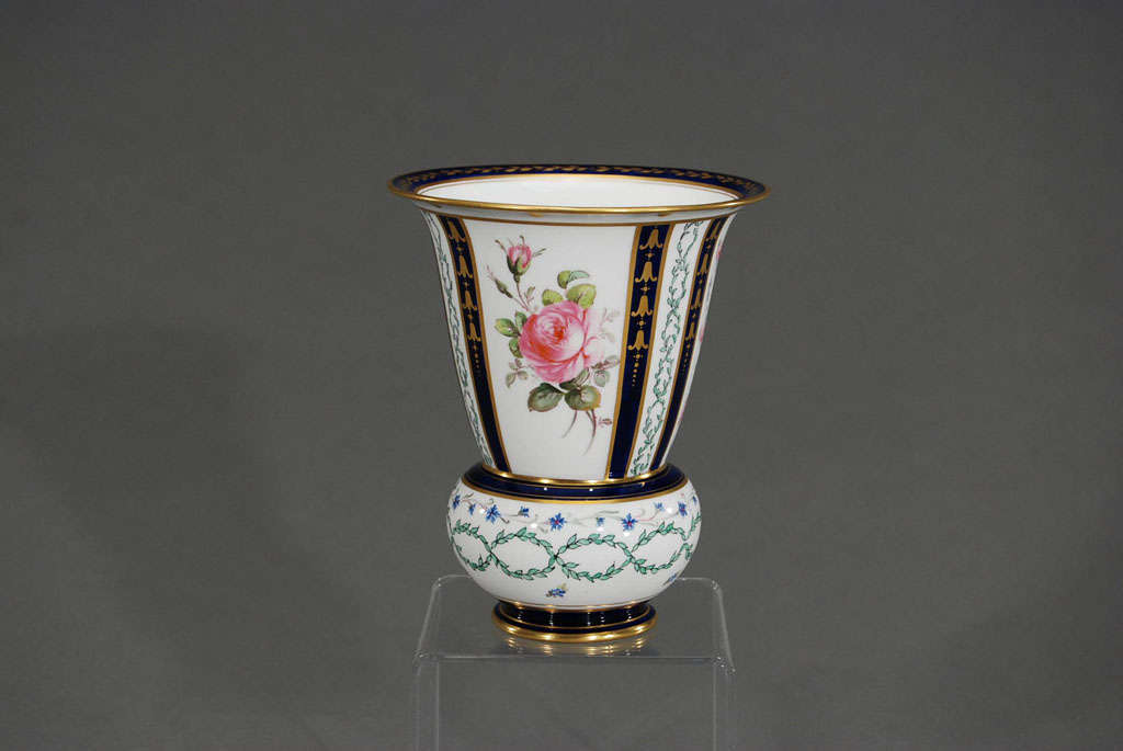 Il s'agit d'un magnifique vase en porcelaine peint à la main, à la fois décoratif et pratique. Une combinaison de bleu cobalt avec de l'or et des roses peintes à la main encerclent le périmètre avec une base large et agréable pour la stabilité dans
