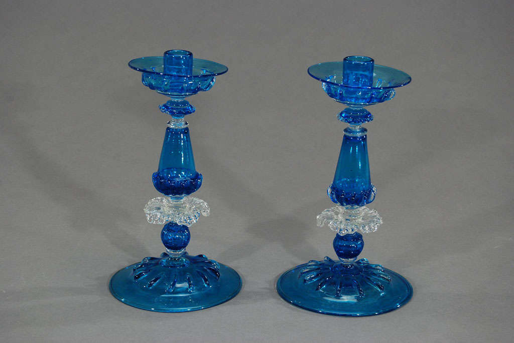 The vibrant color of these turquoise hand blown candlesticks make a bold statement on a table or in a display. Made by Salviati in the 1920's they have removeable bobeches for easy cleaning. They are made by fusing many elements of clear and