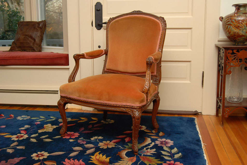 Pair of beautiful and very comfortable French armchairs with original cotton velvet upholstery. The well constructed frame is made of hardwoods and fruitwood carved with prunus flowers and branches on a raised foot. Perfect for an entryway or living