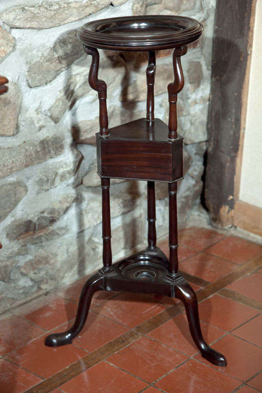 The upper tier of this shaving stand originally would have had an open ring that supported a bowl. It has since been filled with a fine mahogany board, offering the opportunity to place a plant or sculpture in place of the bowl and making this a